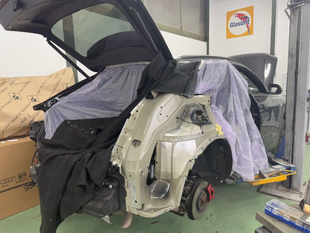 photo d'un véhicule endommagé en pleine réparation dans la carrosserie top gear